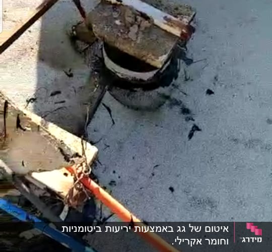 צינורות כתומים וכחולים על גג עם חומר איטום שחור